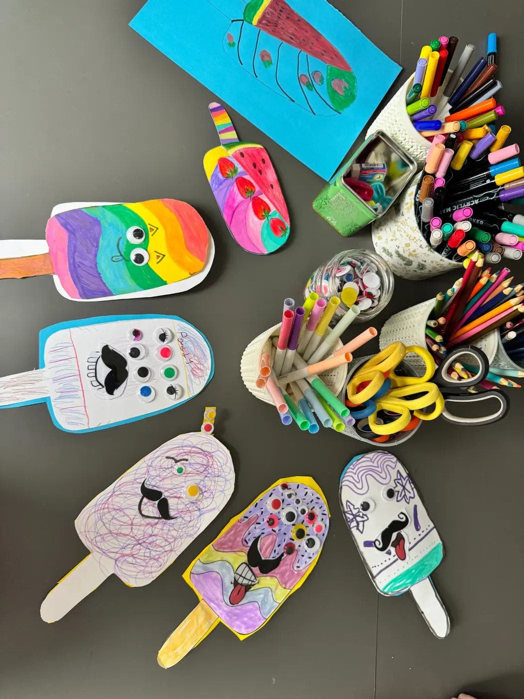 A creative table filled with colourful markers, scissors and children's projects