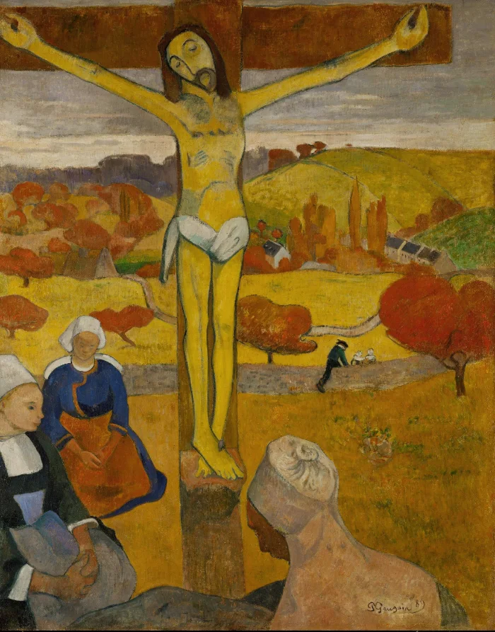 Breton women kneel below a wooden crucifix standing in an autumn field. The figure on it is painted plain yellow, not flesh colour.